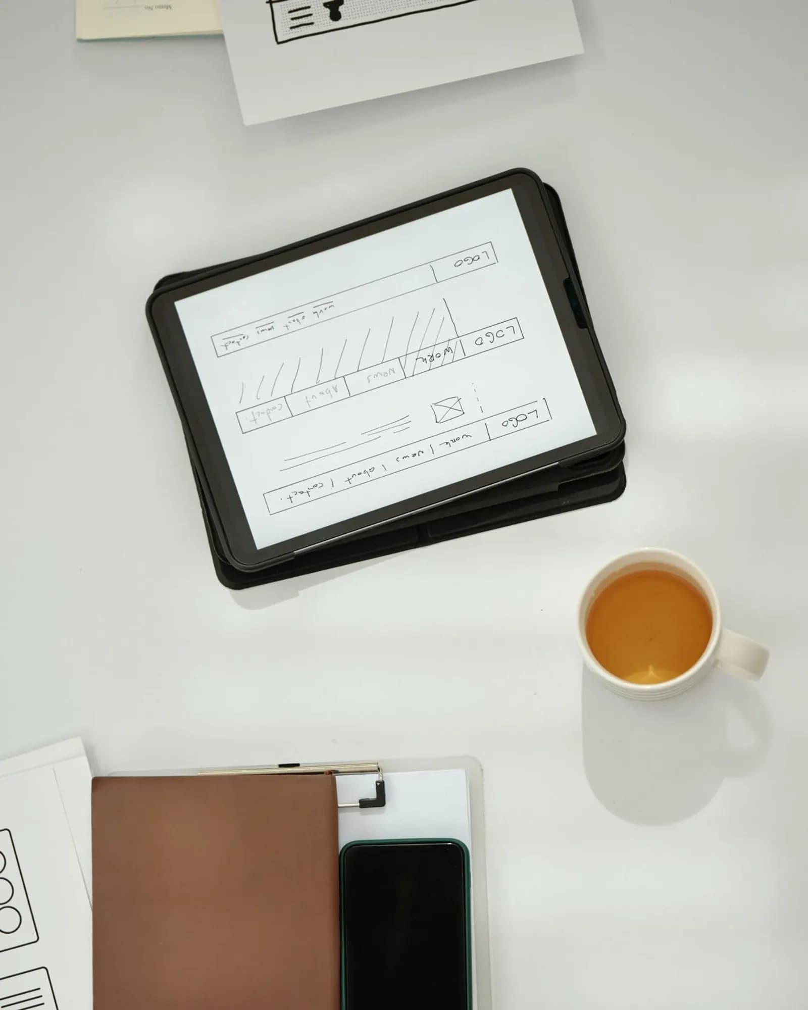 Interface sketches and a tablet on a design desk.