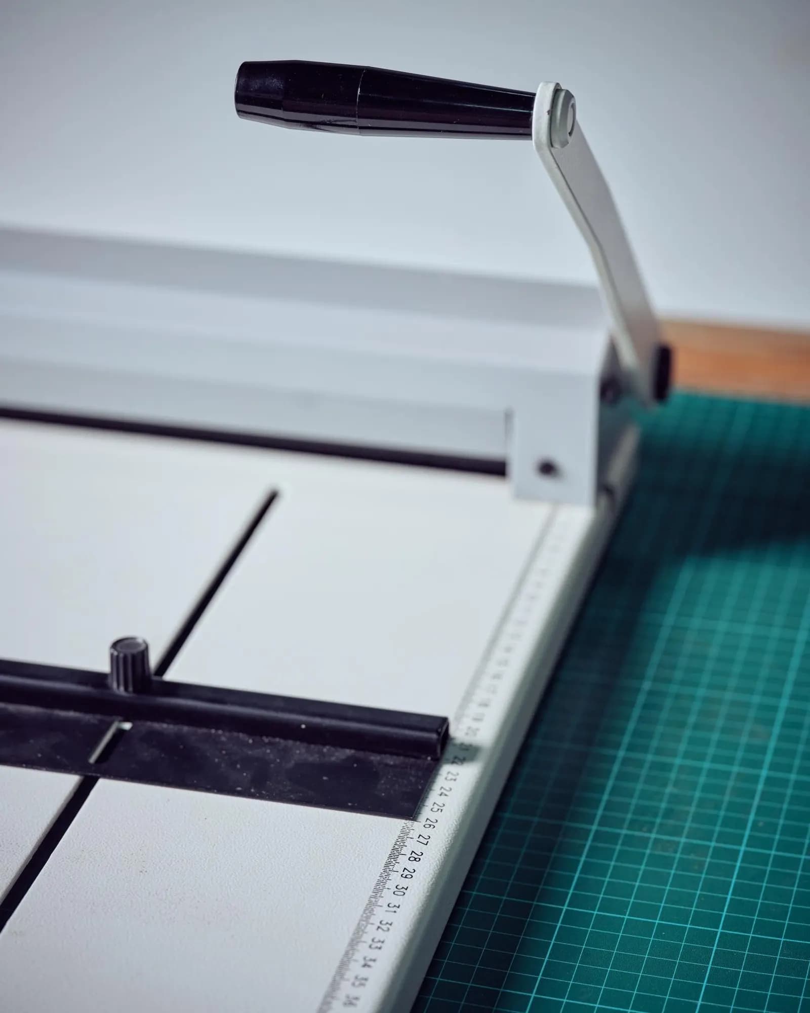 Print finishing tools and paper on a craft table.